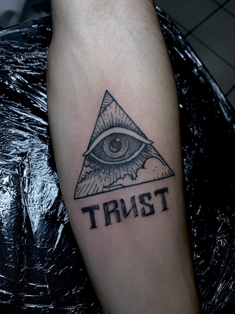 Black and white eye of providence tattoo on arm