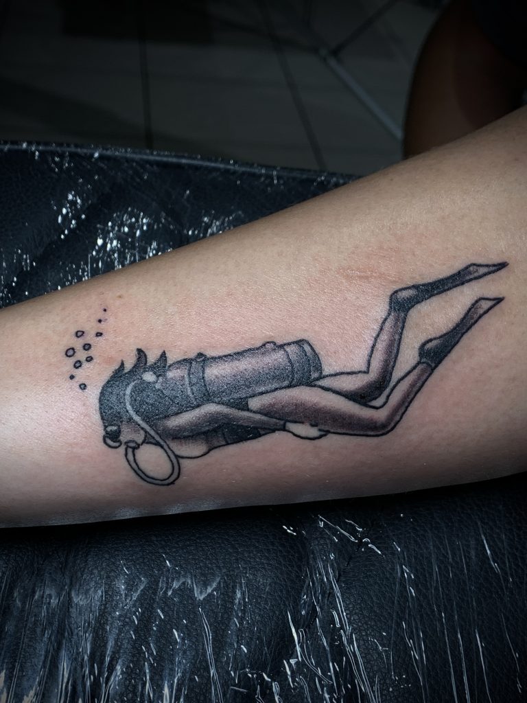 Black and white female diver arm tattoo
