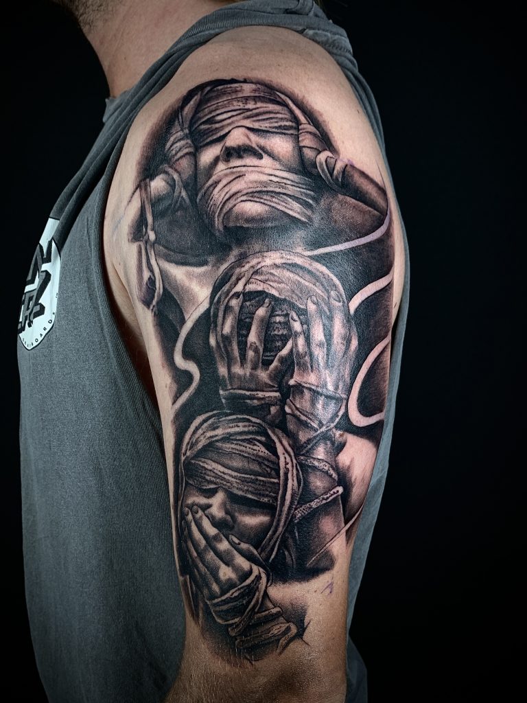 Three bandaged women black and white arm tattoo on man