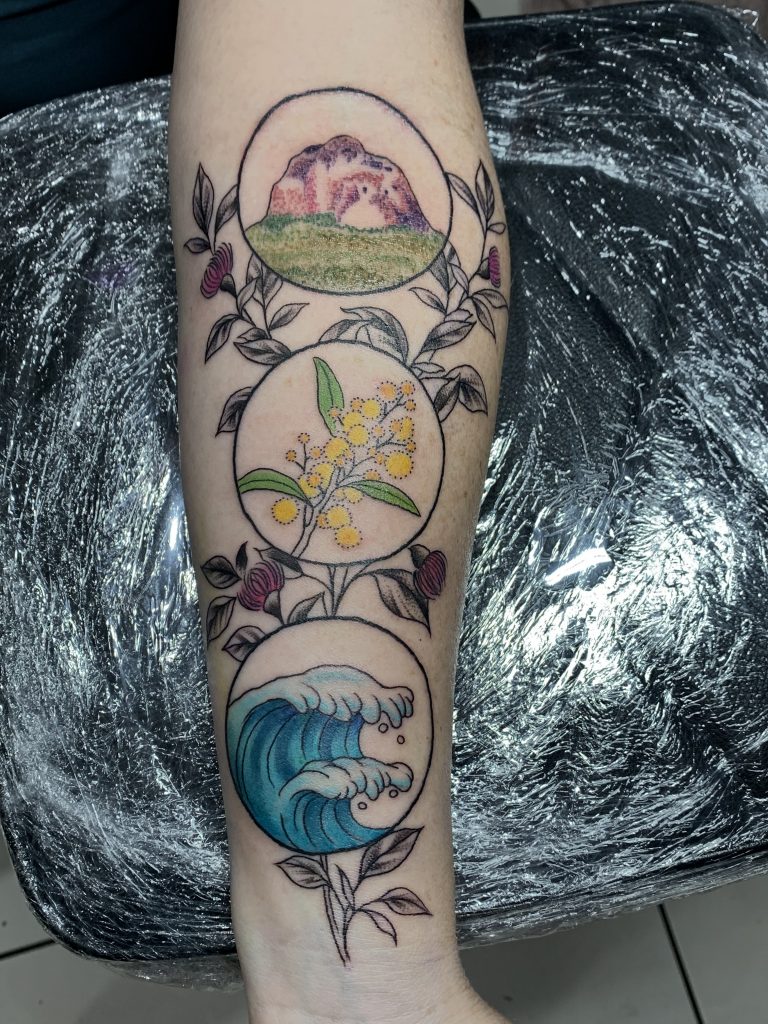 Fine line coloured floral tattoo on arm
