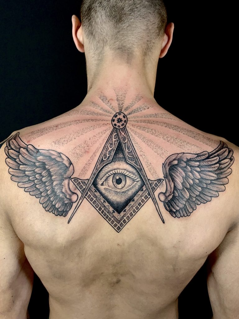 Black and white illuminati with wings back tattoo on man
